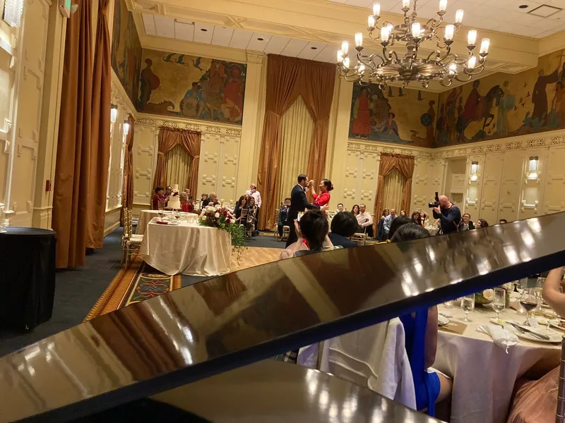 Piano setup in an elegant ballroom with chandeliers
